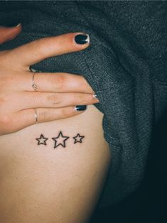 a woman's belly with three stars tattooed on her left side ribcage