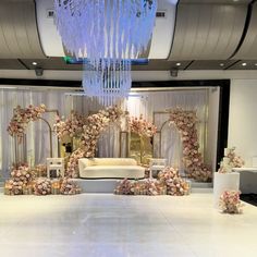 an elegant wedding setup with flowers and candles on the floor, chandelier hanging from the ceiling