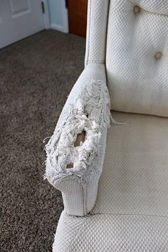 a white chair that is sitting on the floor with a hole in it's back