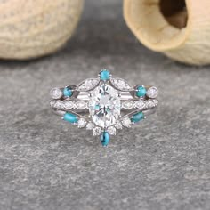 an oval cut diamond ring with blue stones on the sides and white diamonds in the middle