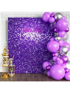 purple and silver balloons are in front of a wall