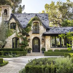 a house that is surrounded by hedges and trees