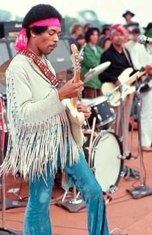 a man playing guitar in front of a group of people