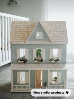 a doll house with flowers in the window boxes