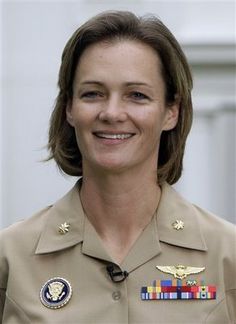 a woman in uniform is smiling for the camera