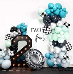 two fast balloons are next to a balloon arch with the number 2 in front of it