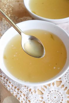 two white bowls filled with soup on top of a doily covered table next to a silver spoon