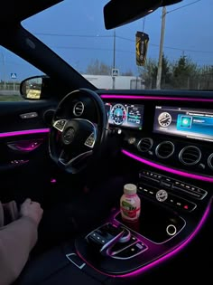 the interior of a car with purple lights and electronic controls on it's dash