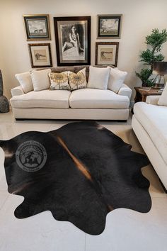 a living room with two couches and a cow hide rug