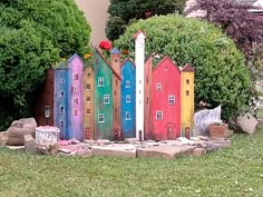 a group of colorful houses sitting on top of a lush green field