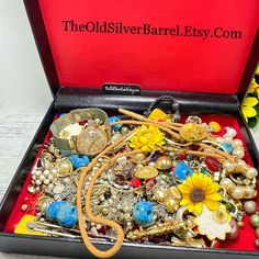 a red box filled with lots of different types of buttons and jewelry on top of a table