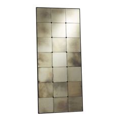 a mirror that is on top of a white wall and has many squares in it