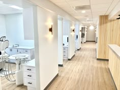 an empty dental office with all white fixtures and wood flooring on the side wall