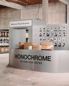 the monochromee booth is set up in an industrial building with cardboard boxes on it