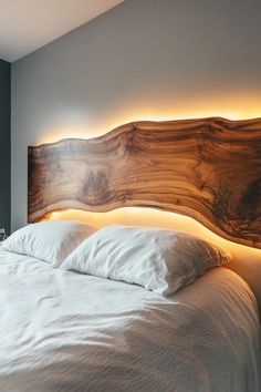 a bed with white linens and wooden headboard