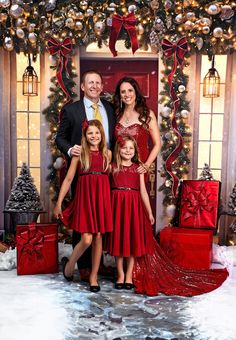 a family posing for a photo in front of christmas decorations