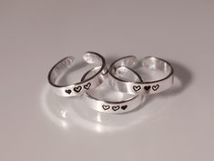 This ring set features hearts and is great for you and your best friend, or your whole friend group! This heart ring set is available in quantities of 2, 3, 4, 5, 6, 7, or 8, making it the perfect ring set for your group of friends. Product Details: Materials: Sterling Silver Color: Silver Size: 3mm Matching Rings You will receive hand-stamped rings filled with a black enamel finish. 3 Matching Rings, Matching Rings For 3 Best Friends, Matching Rings For Trios, Matching Rings For Sisters, Matching Trio Jewelry, Best Friend Rings For 3 Friendship, Friendship Rings For 4 Friends, Friendship Jewelry For 3, Rings For 3 Best Friends