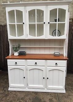 a white hutch with wooden top and drawers