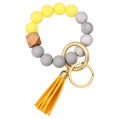 a yellow and grey beaded bracelet with a tassel on the clasp, featuring a wooden block