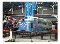 an old fashioned train is on display in a museum with other antique trains and equipment