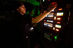 a man standing in front of a control panel