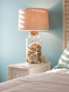 a bedroom with blue walls and a lamp on the nightstand in front of the bed