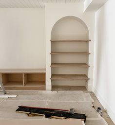 an unfinished room with shelves and tools on the floor