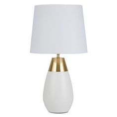 a white and gold table lamp with a white shade on the top, against a white background