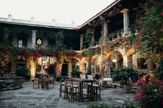 an outdoor dining area with tables and chairs surrounded by greenery on the outside wall