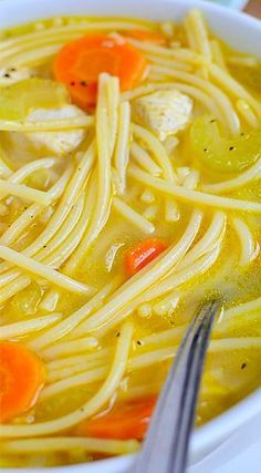 a bowl of chicken noodle soup with carrots, celery and noodles