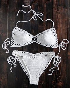 two pieces of white crochet bikinisuit on wooden floor with string attached to the bottom