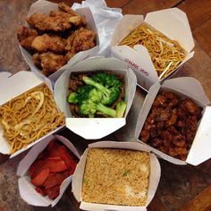 there are many different types of food in the boxes on the table, including broccoli and noodles