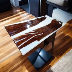 a wooden table with white and brown designs on it in a living room next to a couch