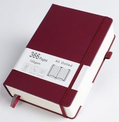 a red and white notebook sitting on top of a table