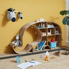 a child's playroom with toys and books on the floor in front of a yellow wall