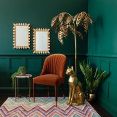 a living room with green walls and a gold dog statue next to a red chair