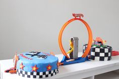 two cakes on a table, one is shaped like a ring and the other is made to look like a race track