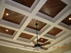 a ceiling with wooden paneling and lights in a room that has white trim on the ceiling