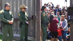 two police officers standing next to each other in front of a group of people watching