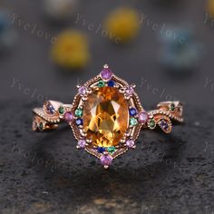 a fancy ring with an orange stone surrounded by multicolored stones and gold plating