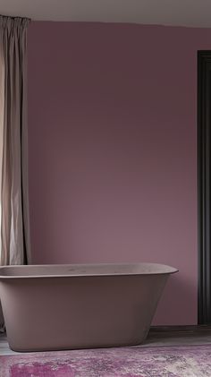 a bath tub sitting on top of a pink rug