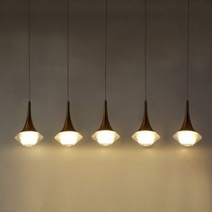 five lights hanging from the ceiling above a table