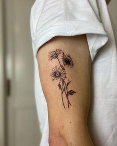 a black and white photo of a flower on the back of a woman's arm