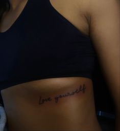 a woman's stomach with the words love yourself tattooed on it