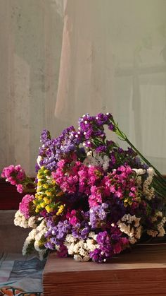 a bouquet of flowers sitting on top of a wooden box