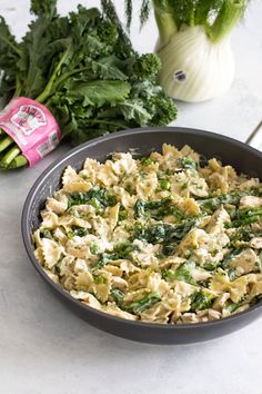 a pan filled with pasta and vegetables on top of a counter next to other ingredients