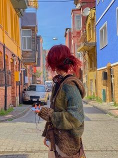 a woman with red hair is walking down the street