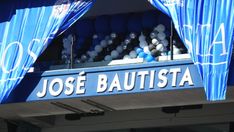 a blue sign that says jose bautista hanging from the side of a building