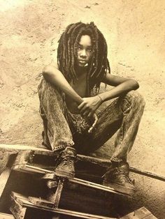 a man with dreadlocks sitting on the ground