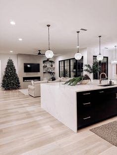 a large kitchen with an island in the middle and christmas decorations on the counter top